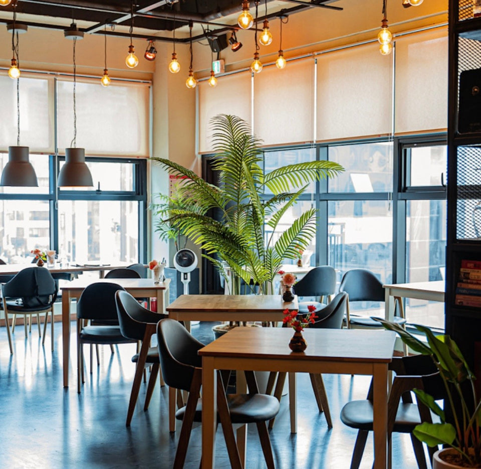 The dining room at Restaurant Iluka in Jeonju, with pendant lights and daylight from the street windows